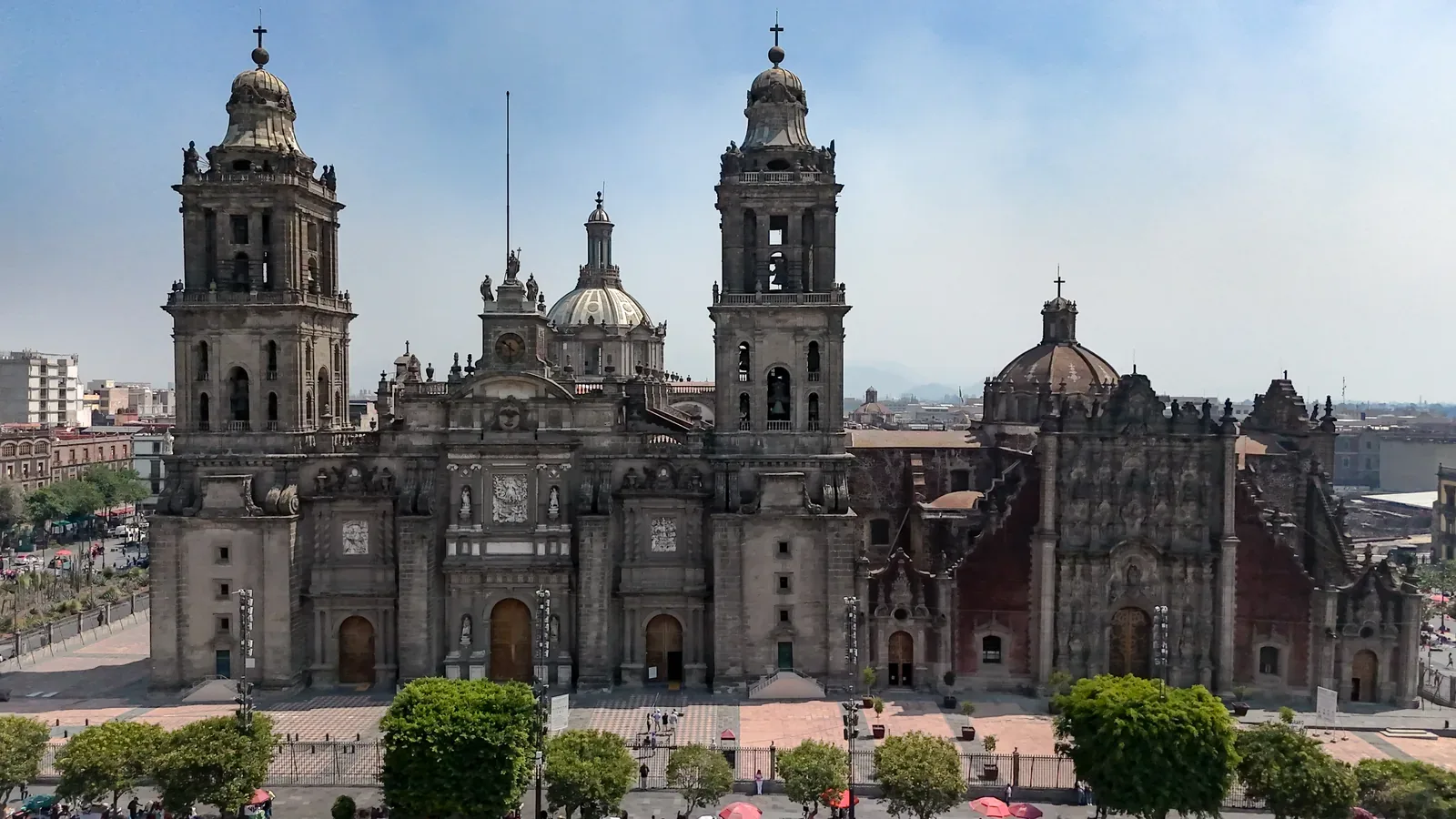 Catedral Metropolitana de la Ciudad de México — Metropolitan Cathedral of Mexico City with its baroque facade, domes, and bell towers under a clear sky. The imposing stone structure dominates the urban landscape of the Zócalo.